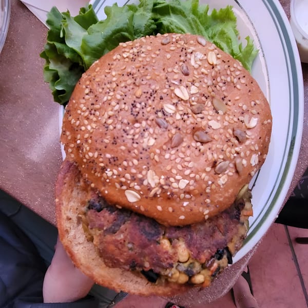A Carpo's Restaurant veggie burger with lettuce on a seeded bun, viewed from above.