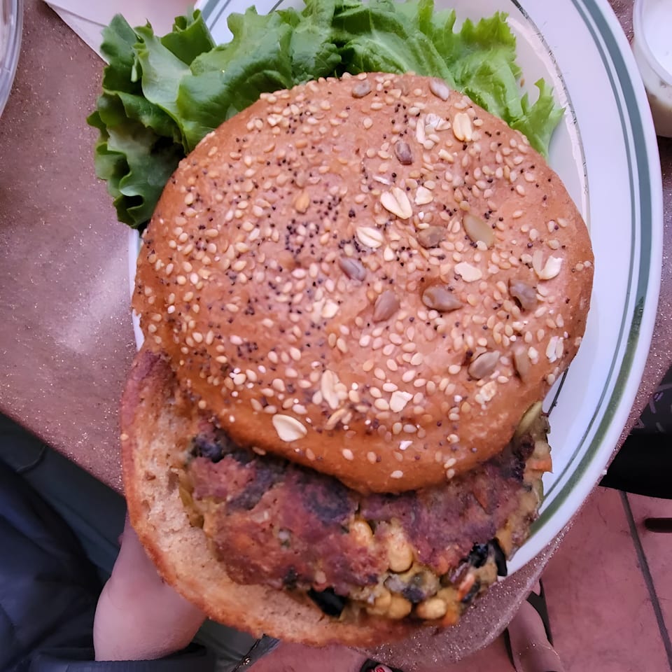 A Carpo's Restaurant veggie burger with lettuce on a seeded bun, viewed from above.